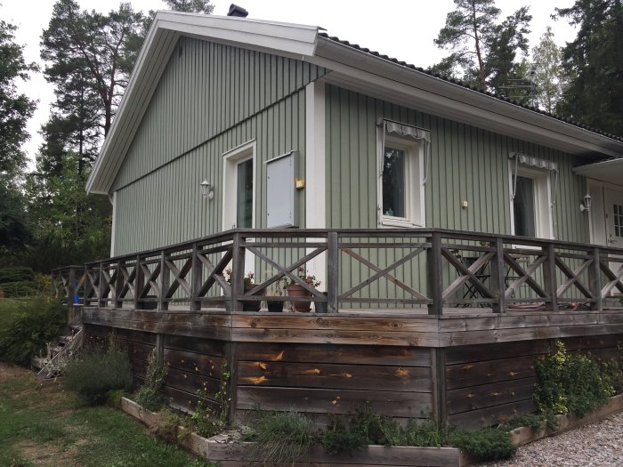 Slitet träaltandäck med 22x200 brädor mellan fris och rabatt, omgivet av stolpar och vegetation.
