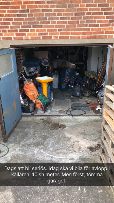 Garage fullt med diverse föremål och verktyg inför arbete med avlopp i källare.