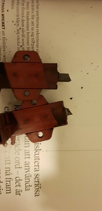 Två överlappande rostiga tänger med släta huvuden mot vit bakgrund.