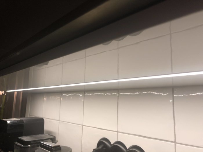 LED-tejp integrerad i kökets täckskiva ovanför kaklade väggen.