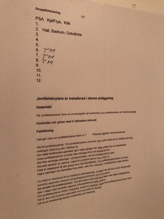 Etikett i elskåp med gruppindelning och instruktioner för jordfelsbrytare samt felsökning.