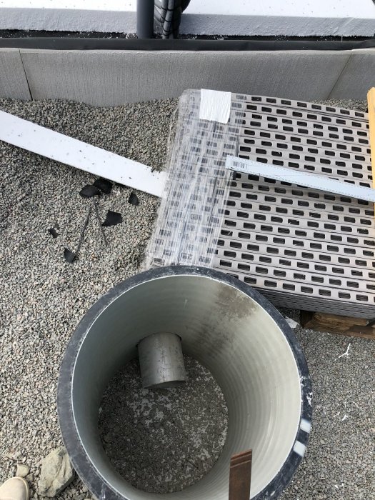 Rostfritt svetsat rör för köksö och kamin, med grus och byggmaterial i bakgrunden.