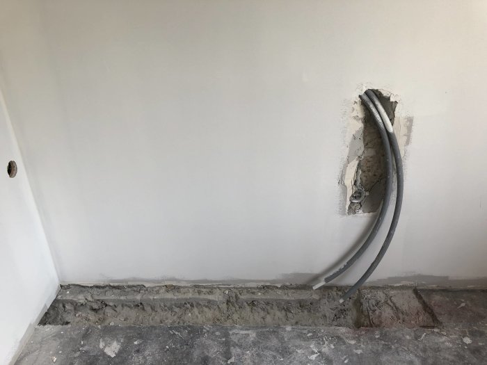 Öppet schakt i köksvägg med synliga rör för kallt och varmt vatten samt utgående avlopp.