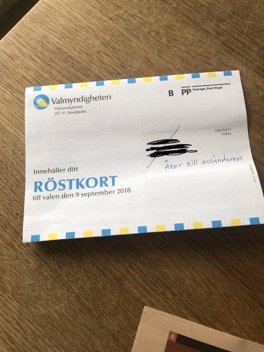 Röstningskort för valet med överstruket namn och texten "åter till avsändaren" skrivet på det.