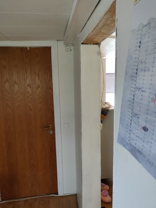 Ojämn vägg vid dörrpost med varierande tjocklek, synlig måttanmärkning.