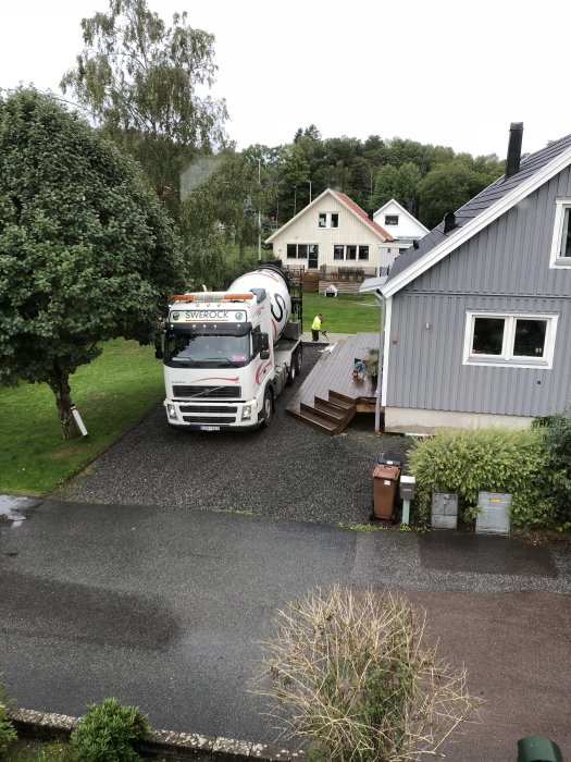 Nyglättad betongplatta med betongbil och arbetare i bostadsområde.