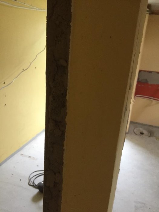Öppning i en källarvägg av lekablock klädd med puts, förberedd för att byggas igen.