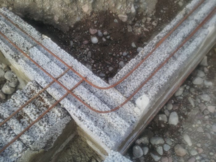 Grundisolering med kantelement och armeringsjärn före betonggjutning, hörnkant ska bort.