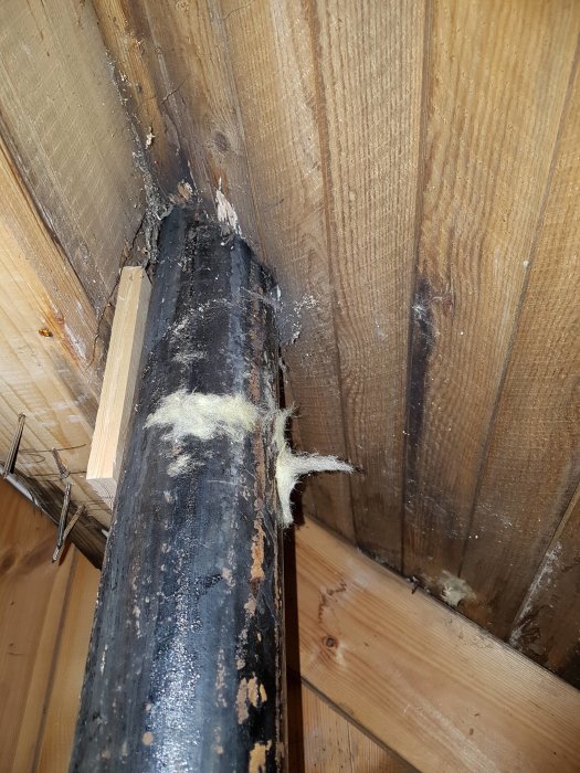 Äldre avloppsrör som löper genom ett träregelverk i ett pågående renoveringsprojekt av en toalett.