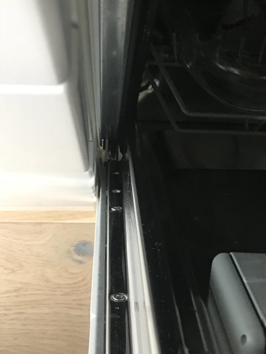 Närbild på öppen diskmaskin som visar det trånga utrymmet mellan maskindörren och skåpstommen.