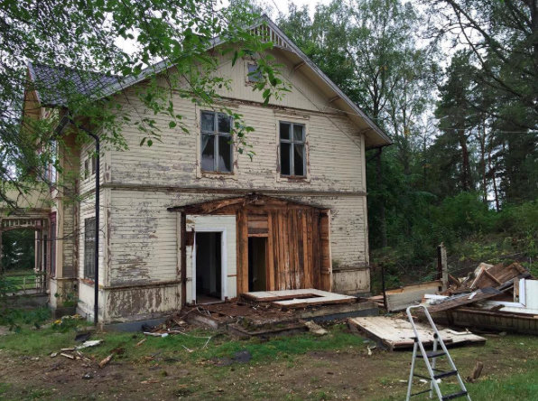 Gamla huset under renovering med bråte och en stege utanför den norra grovingången.