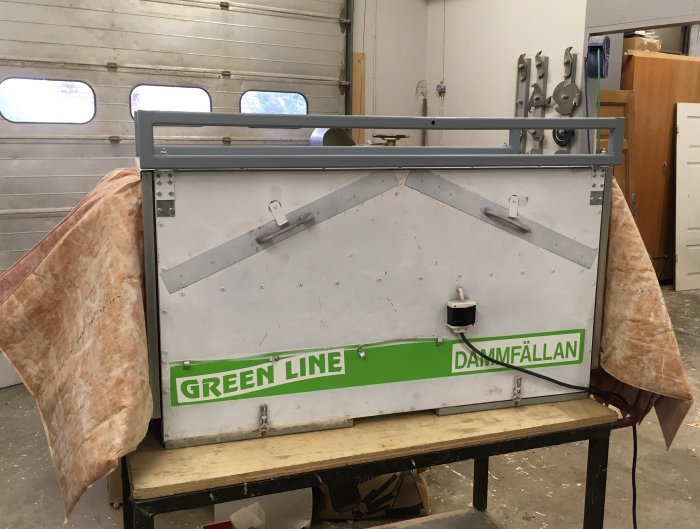 Modifierad upphängning och nymålad luftrenare med texten "GREEN LINE DAMMFÄLLAN" i en verkstad.