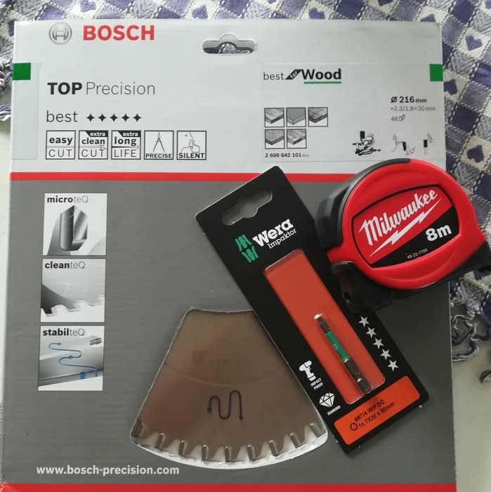 Bosch kapskives förpackning, Wera skruvmejsel och Milwaukee måttband på ett bord.