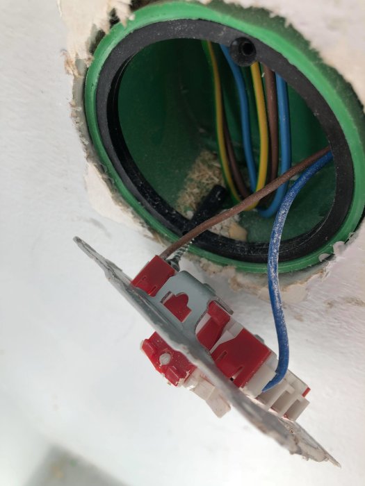 Elektriska kablar och en strömbrytare inuti en väggöppning för en garageport.