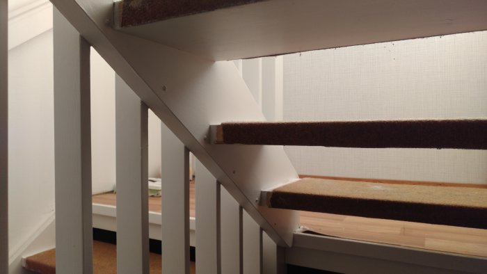 Trappsteg klädda med matta som går ner över fram- och bakkanten, fästa med kontaktlim.