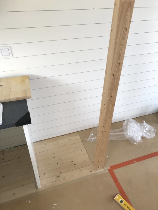 Påbörjad konstruktion av spiraltrappa i sjöbod med verktyg och trämaterial.
