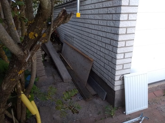 Garagevägg med vit sockel, frågan är om kabeldragning ska ske i sockeln eller högre upp.