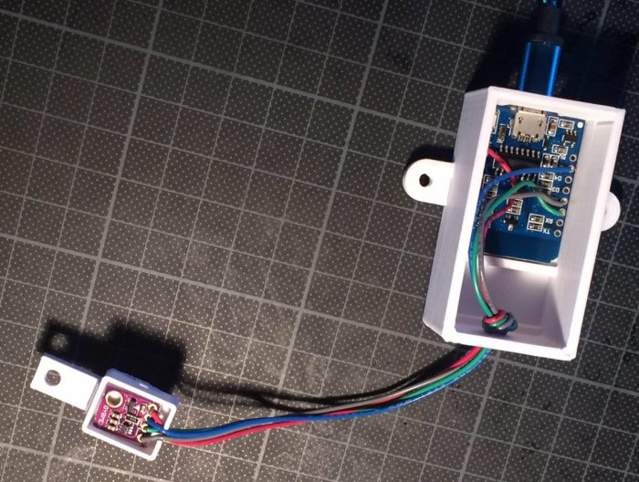 En Wemos D1 mikrokontroller ansluten till en BMP280 sensor för mätning av temperatur och lufttryck på ett rutigt underlag.