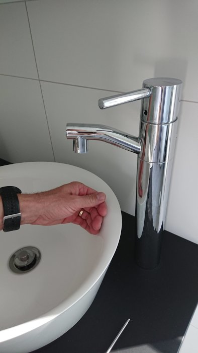 Närbild på nya längre kranpiphuvudet jämfört med det korta ursprungliga, monterade på en badrumsblandare.