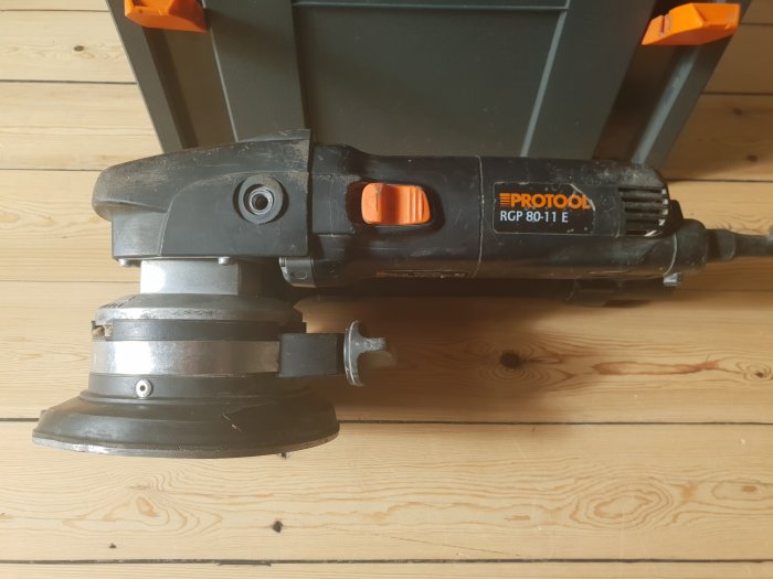 Använd Protool RGP 80-11 renoveringsfräs med synlig spricka i dammkåpan, mot träbakgrund.