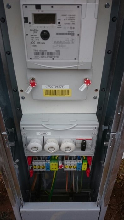 Elcentral med energimätare, säkringar och kablar, ineffektivt utnyttjad utrymme.