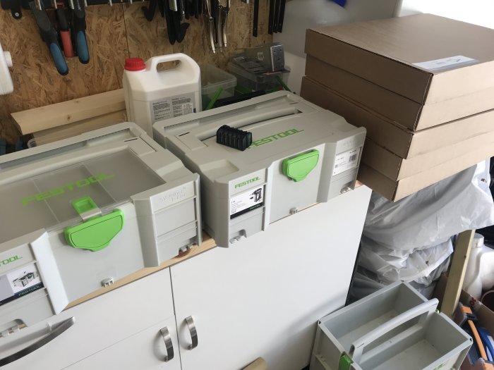 Verktygslådor från Festool i en verkstad med oöppnade kartonger, antydan om nyinköpt C18 borr.