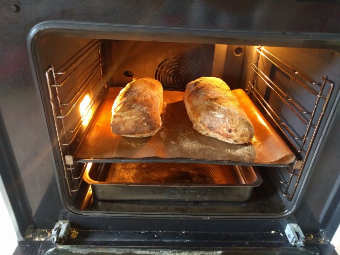 Två nybakade bröd i en öppen ugn, bakade av en person som erbjuder att baka för besökare.