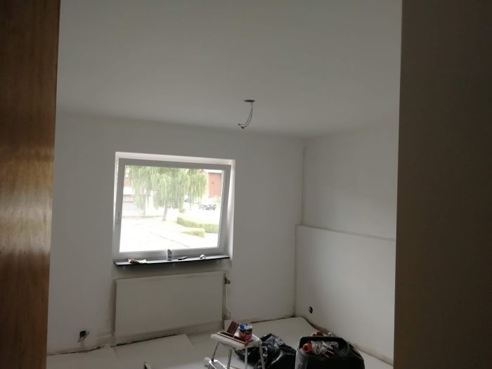 Renoverat sovrum under arbete, med nymålade väggar och en osynlig gipsvägg.