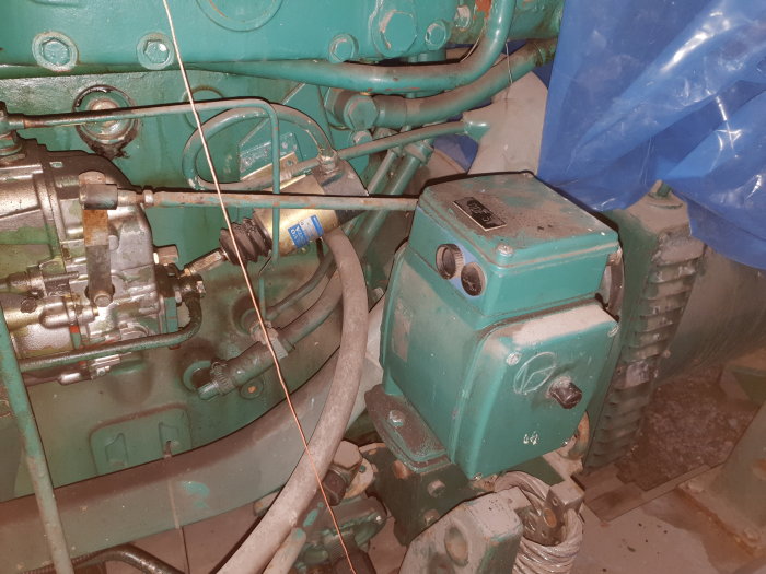 Volvo Penta motor och delar av Hitzinger generatorn med hoprullad kabel och okänd komponent.