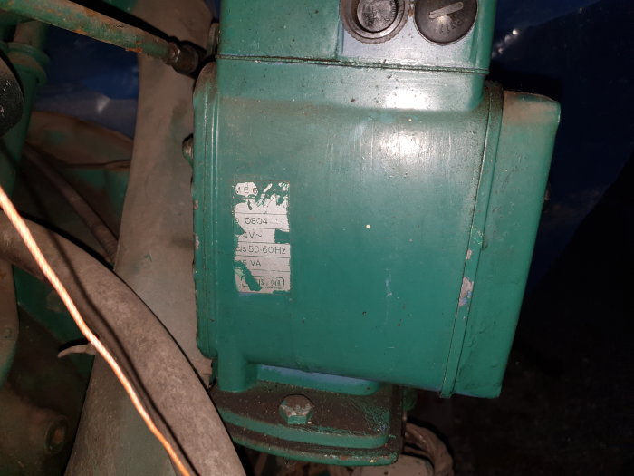 Grönt mekaniskt aggregat med en etikett som visar "ME6 0804 24v~ 50-60hz ?5VA Landis & Gyr".