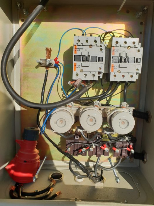 Elektriskt kontaktskåp med oansluten kabel, kontaktorer, mätare och klippt kabel till fläkt.