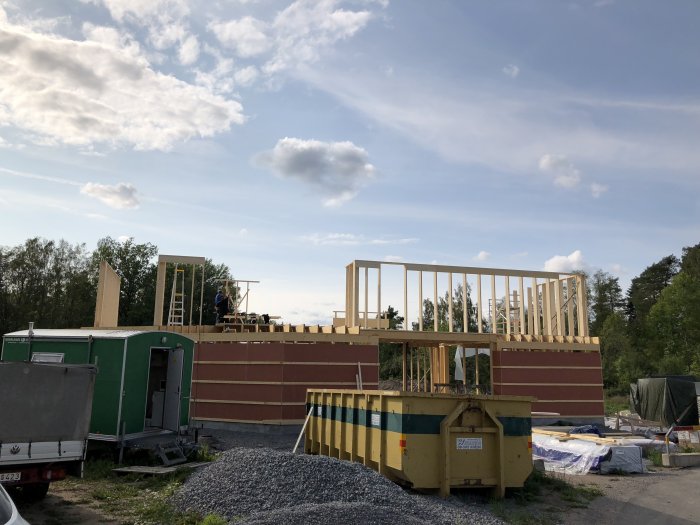 Montering av impregnerat gips på trästommen på en byggarbetsplats under klar himmel.