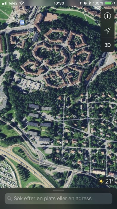 Satellitbild över ett blandat bostadsområde med både radhus och villor omgivet av gröna träd.