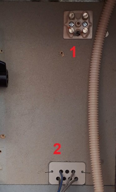 Interiör av elskåp med numrerade komponenter, inklusive okända anslutningar och potentiell mätaranslutning.