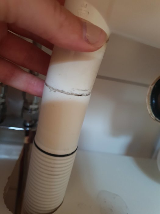 Hand håller två rör med samma diameter där det ena inte går in i det andra.