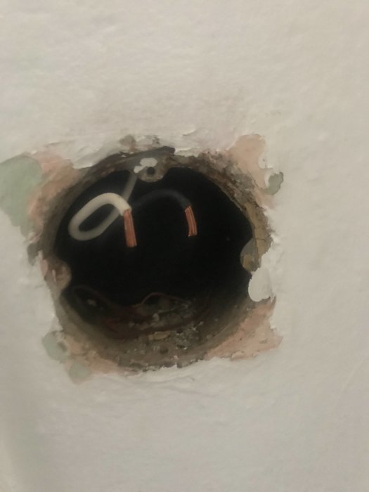 Öppen elinstallation med oskyddade elsladdar i en vägg.