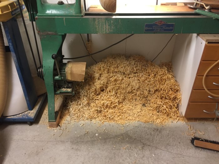 Träspånor på golvet vid en svarv i en verkstad efter grovsnittning av poppel.