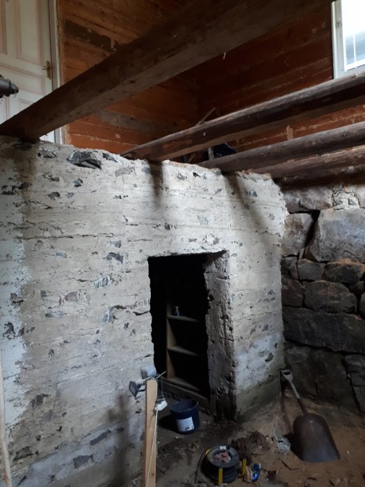 Renovering av gammal källare med nakna stenblocksväggar och utsatt träbjälklag som förbereds för gjutning av platta.