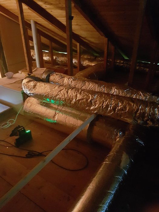 Isolerade ventilationsrör på en vind under installationen av ett FTX ventilationssystem i ett pågående renoveringsprojekt.