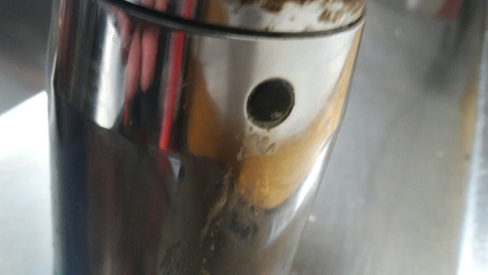 Närbild av äldre Mora-köksskran med liten rund detalj och synliga kalkavlagringar.