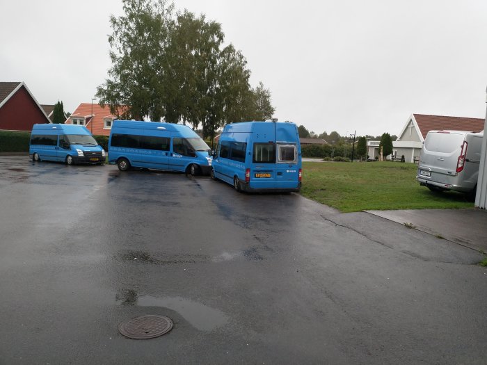 Tre blå handikappbussar parkerade i en vändzon i ett bostadsområde, blockerar området.