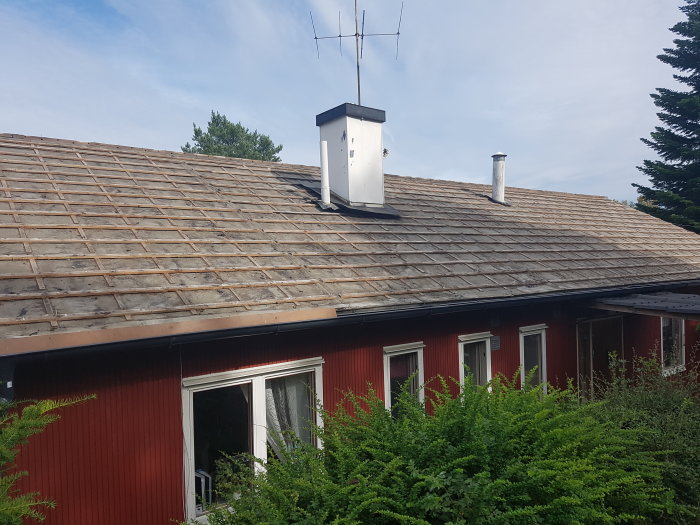 Renoveringsarbete på ett äldre hus med takspont och ströläkter synliga, innan omläggning av tak.