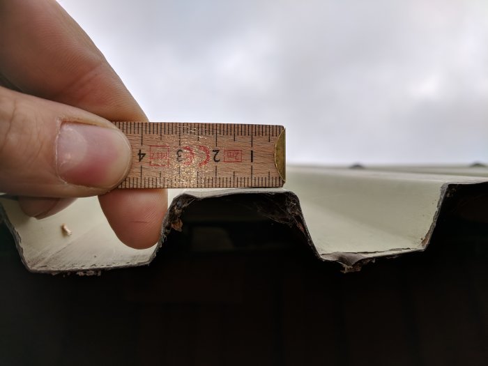 Mätning av takplåtens profil med tumstock för att identifiera typ av plåt.
