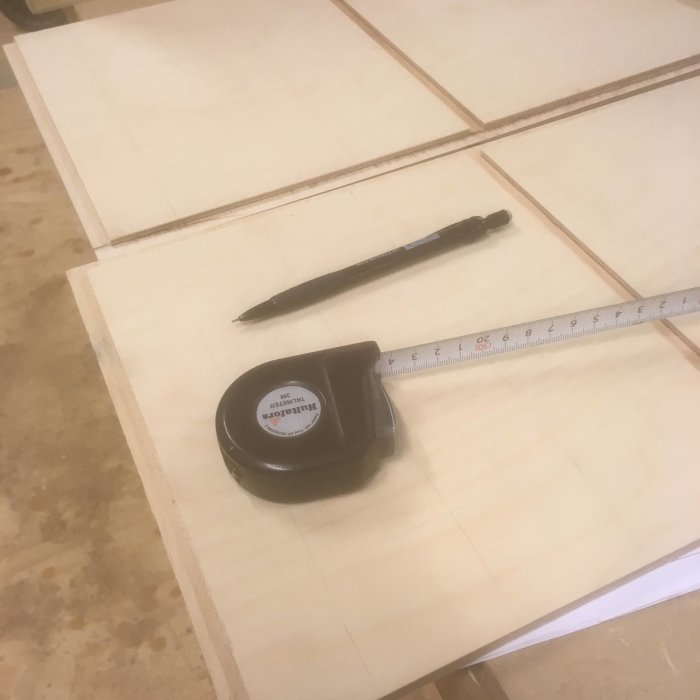 Snickeriprojekt med uppmarkerade träskivor, måttband och penna.