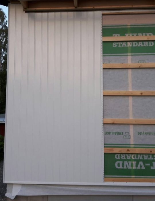 En vägg med nyinstallerad, halvblank PVC-panel utan synliga skruvar eller spikar.