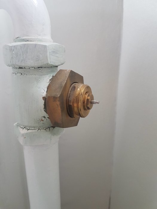 Äldre vred utan termostat på en sektionsradiator med synliga gängor.