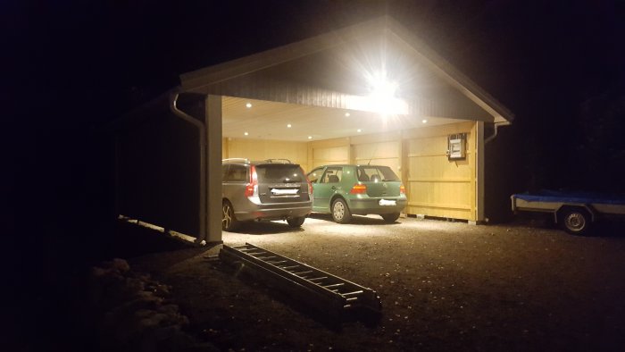 Upplyst carport i mörkret med två parkerade bilar och en 5W strålkastare som lyser klart över området.