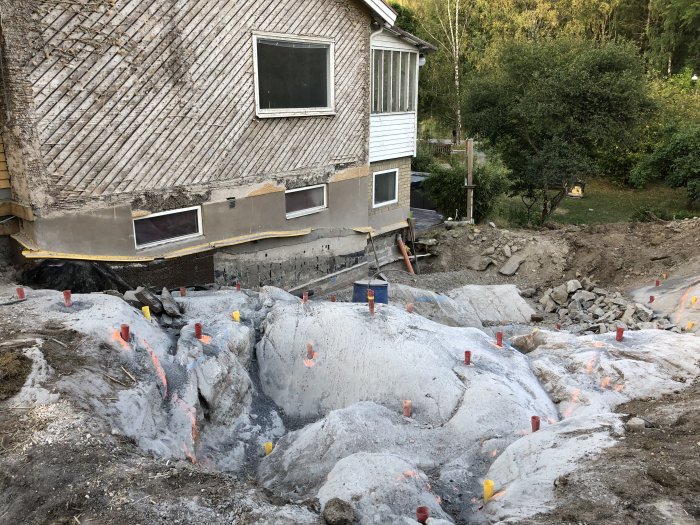 Bergspräckning vid husgrund där stora bergspartier har borrats för att göra plats för tillbyggnad.