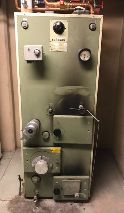 Gammal Euronom A25F kombipanna i ett pannrum, utan oljebrännare, med synliga reglage och mätinstrument.