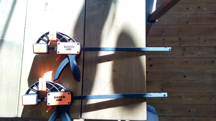 Två nya Bahco snabbtvingar på ett trägolv i solljus.